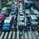 Scooters and motorcycles filtering lanes in Bangkok traffic